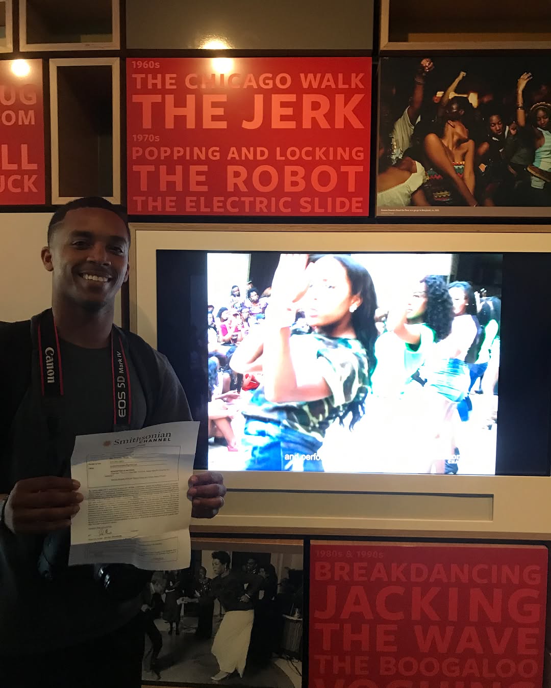 Holding the Smithsonian Channel license beside the footage playing in the museum
